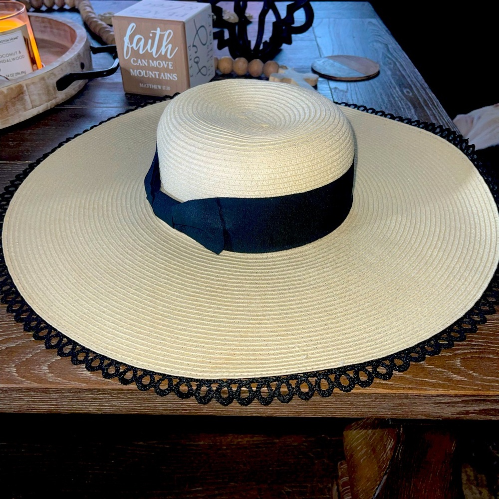 Beautiful beach hat, straw with black design fringe and bow belt.